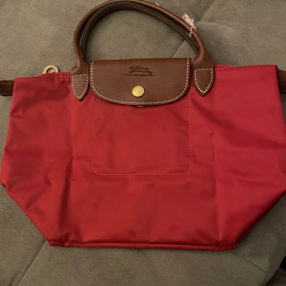 Longchamp handbag. Leather handles and flap. Interior pocket. 4” drop handles.